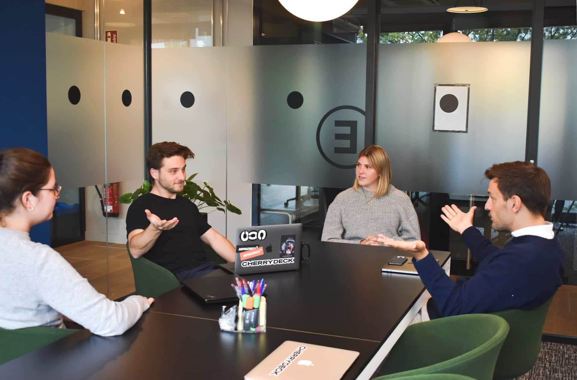 Ein Team sitzt zusammen an einem Schreibtisch und diskutiert