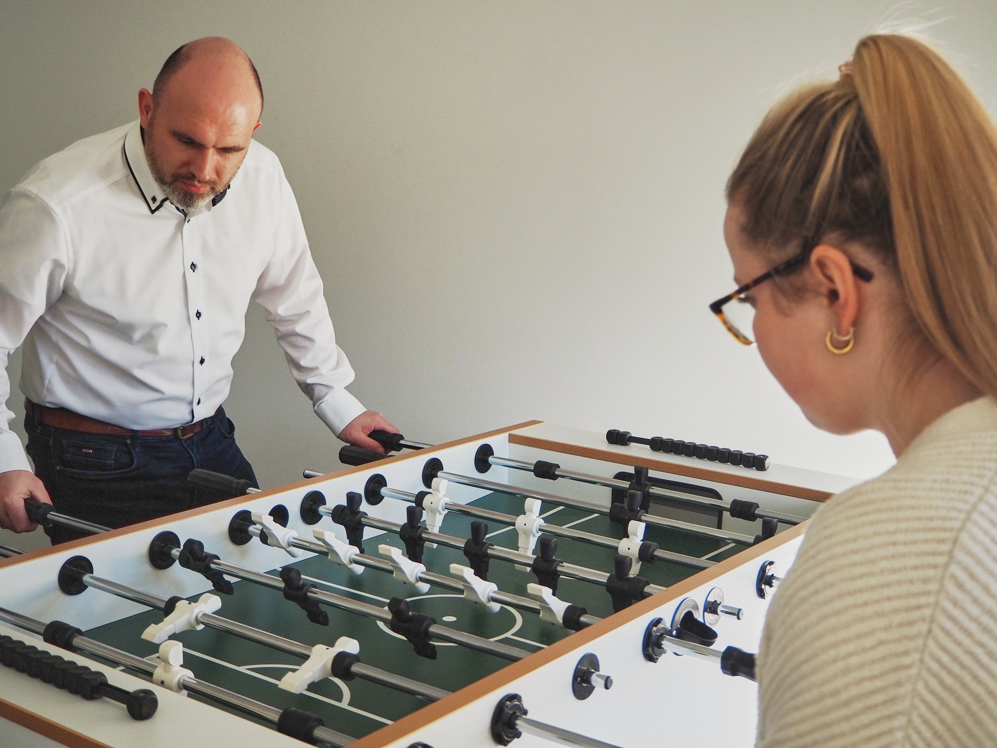 factro kicker Kickertisch im Büro an dem zwei Mitarbeitende stehen