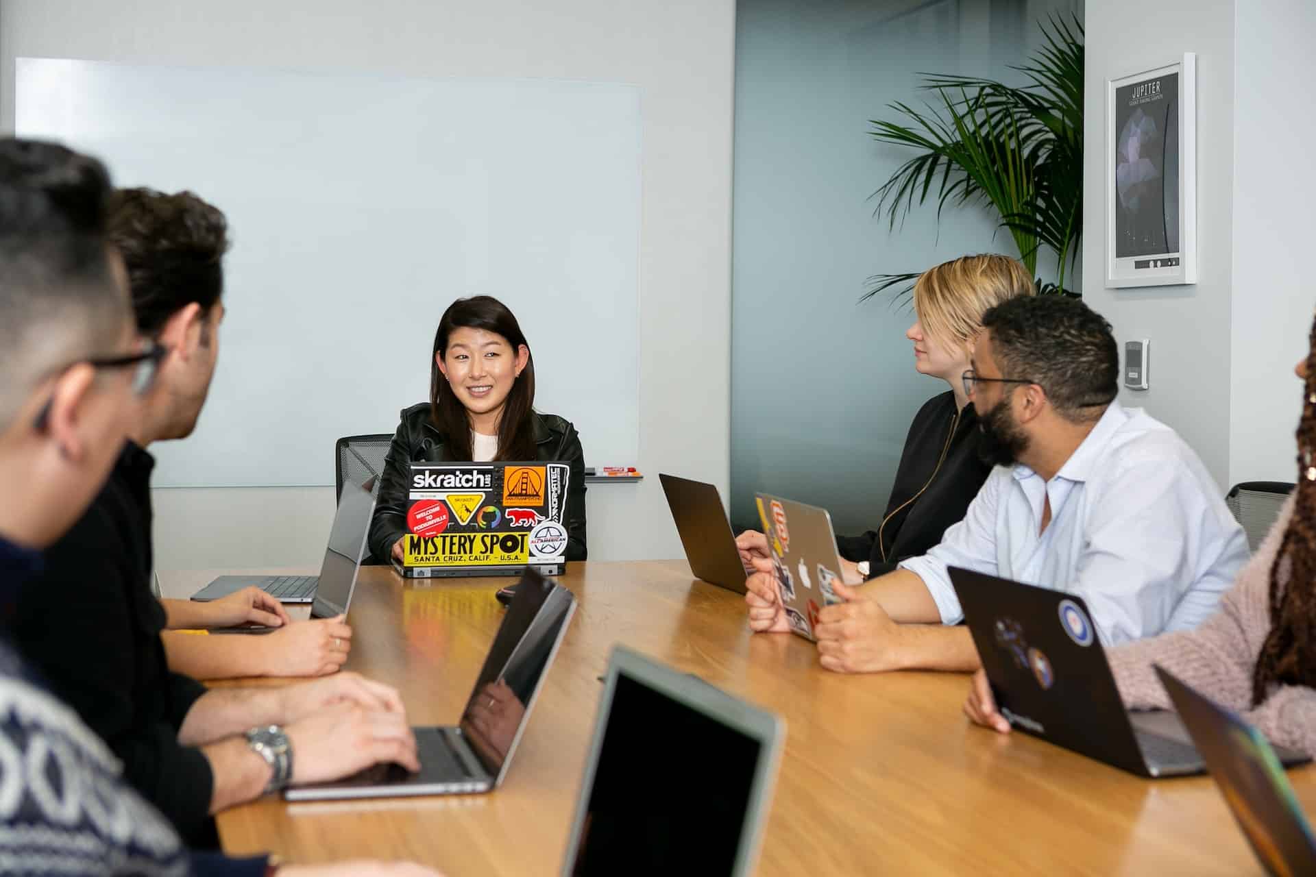 Mehrere Personen sitzen an einem Tisch und haben ein Meeting