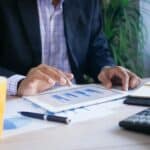 So geht Ressourcenplanung im Projektmanagement Eine Person sitzt vor einem Tablet und tippt etwas