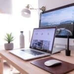 Desk Sharing Konzept: Definition, Vorteile & Regeln Ein Schreibtisch auf dem ein Laptop und dahinter ein Bildschirm steht.